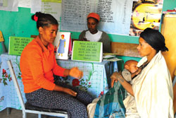 A health professional talks to a mother about immunization and family planning at her postnatal checkup.