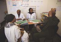 Health professionals meet with significant people from the community in their office.